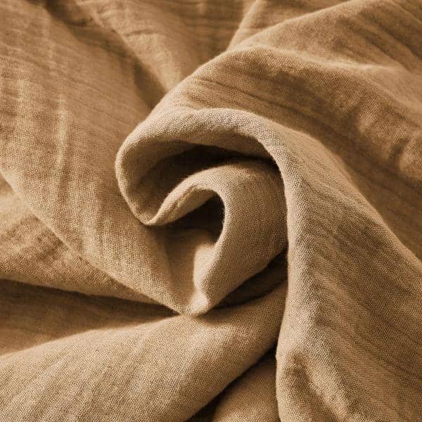 Tissu beige en gaze de coton doux et léger avec texture froissée visible de près