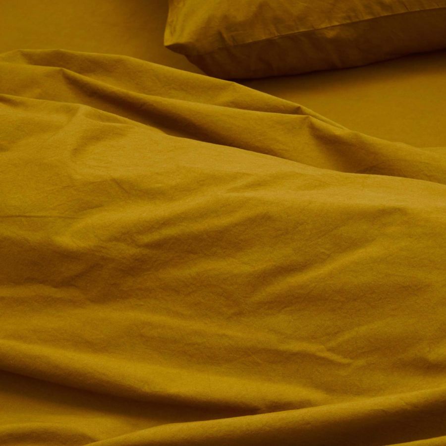 Draps en coton jaune ocre doux et confortable montrant la texture naturelle de le coton