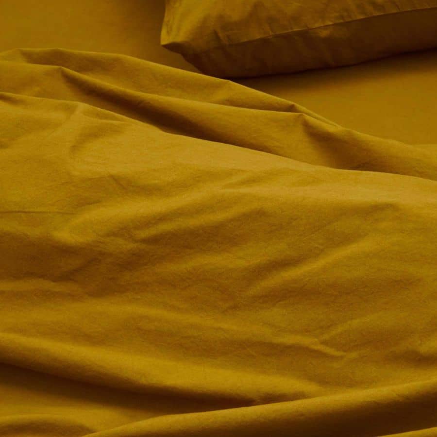 Draps en coton jaune ocre doux et confortable montrant la texture naturelle de le coton