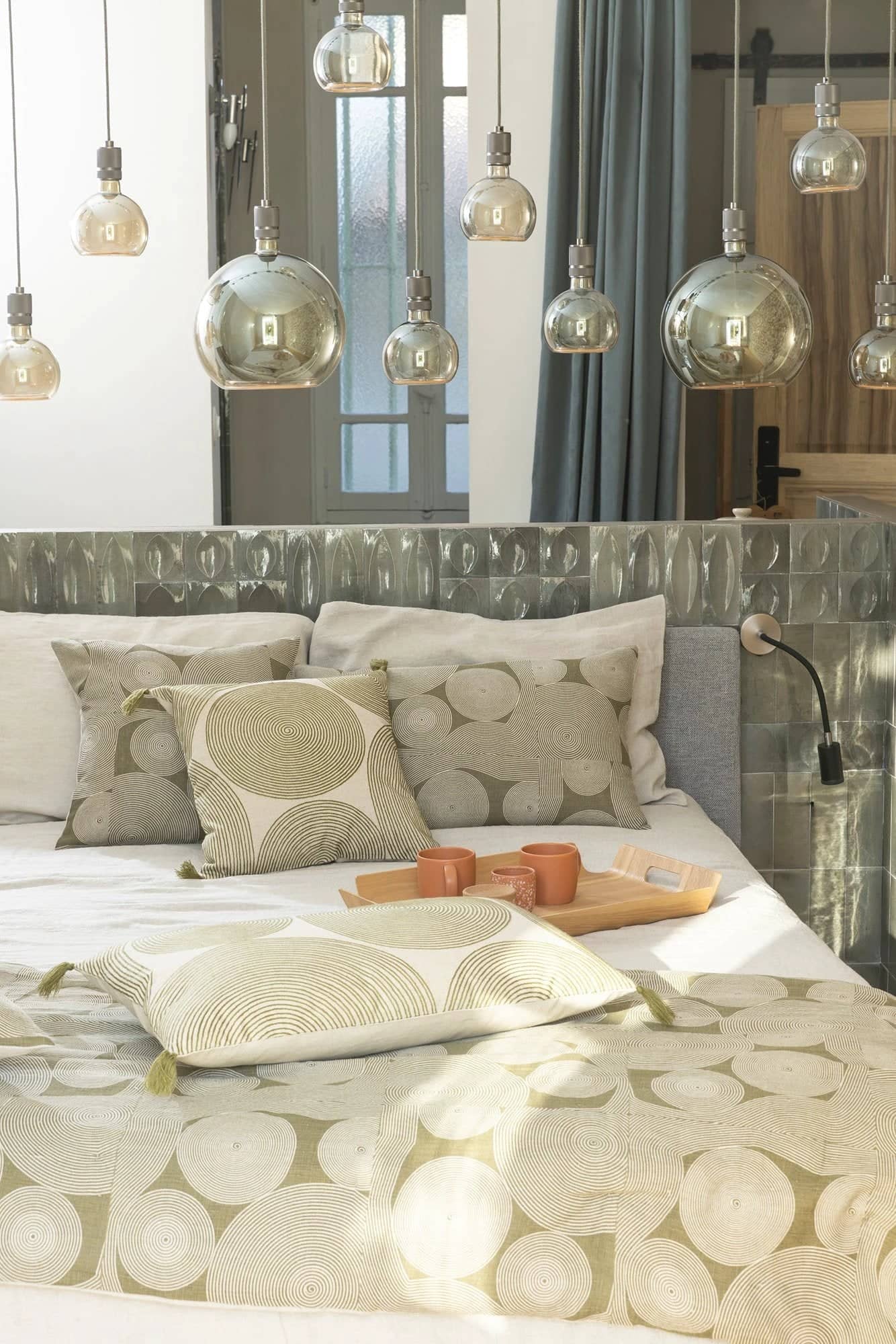 Chambre élégante avec lit décoré de tito linge de maison beige et motifs circulaires