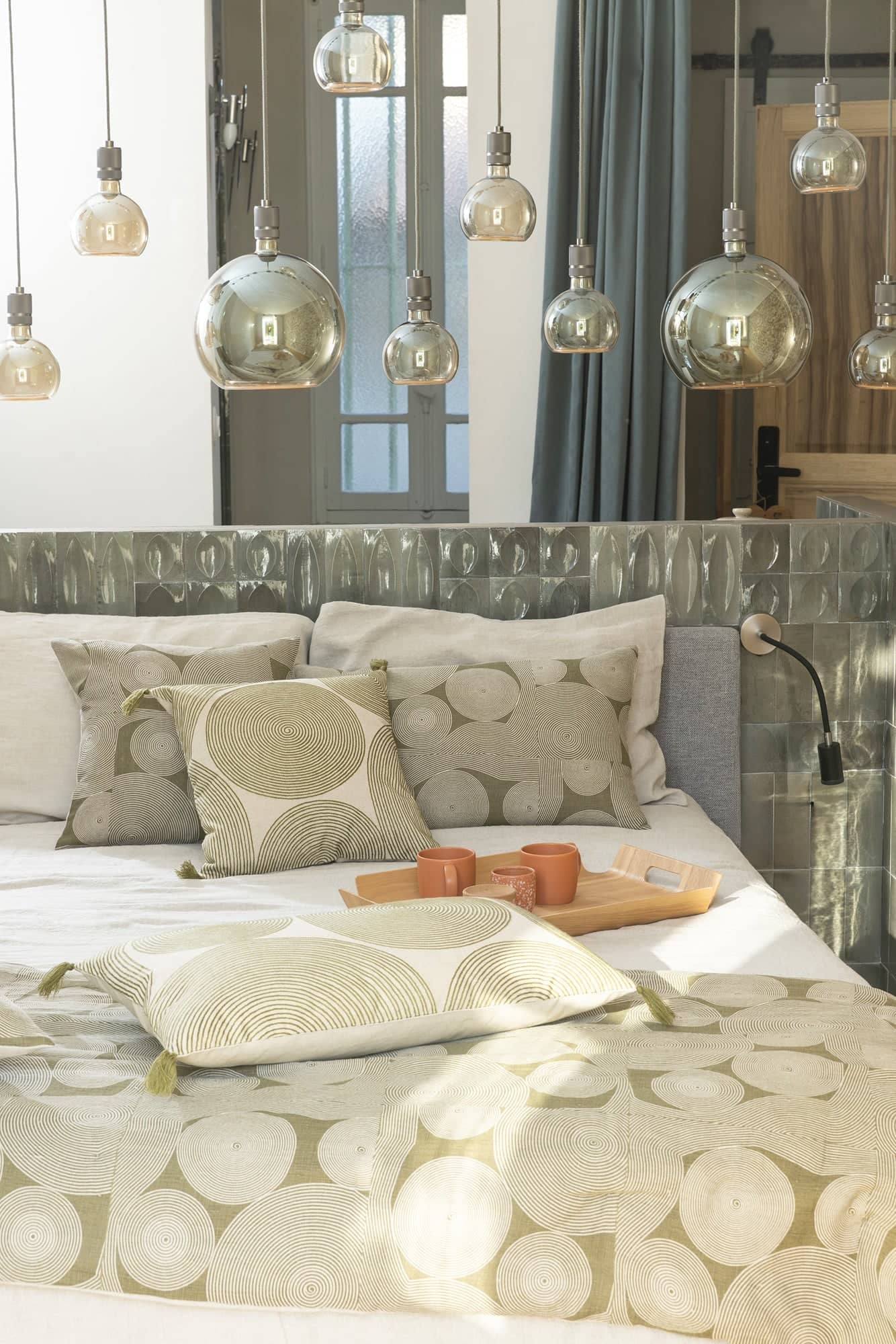 Chambre lumineuse avec lit habillé de linge de lit en coton bio beige à motifs ronds