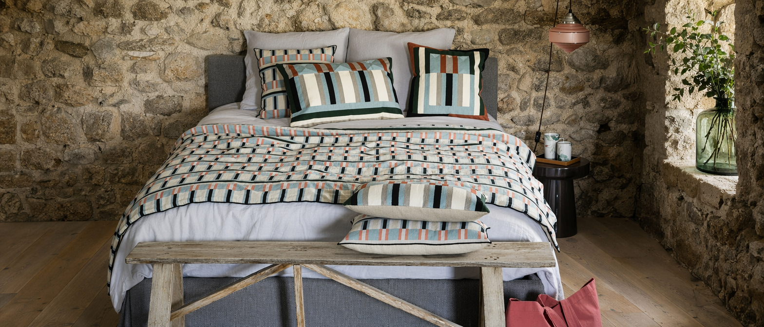 Chambre décorée avec linge de lit en chanvre aux tons naturels et coussins à motifs floraux