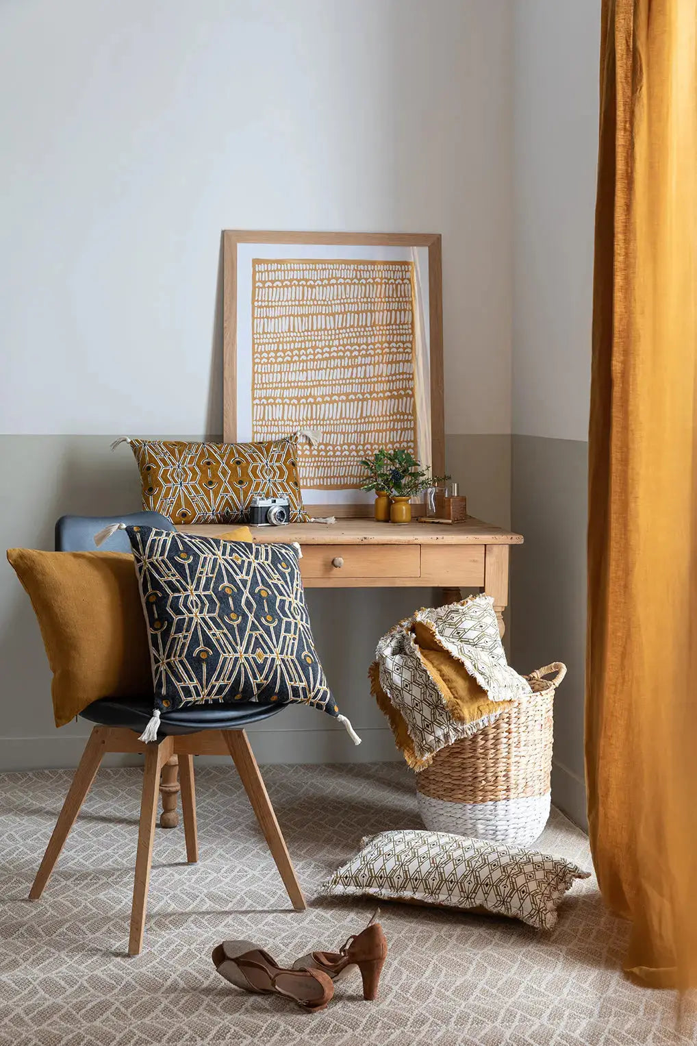 Intérieur cosy avec rideau en lin naturel ocre, chaise avec coussins décoratifs et bureau en bois clair