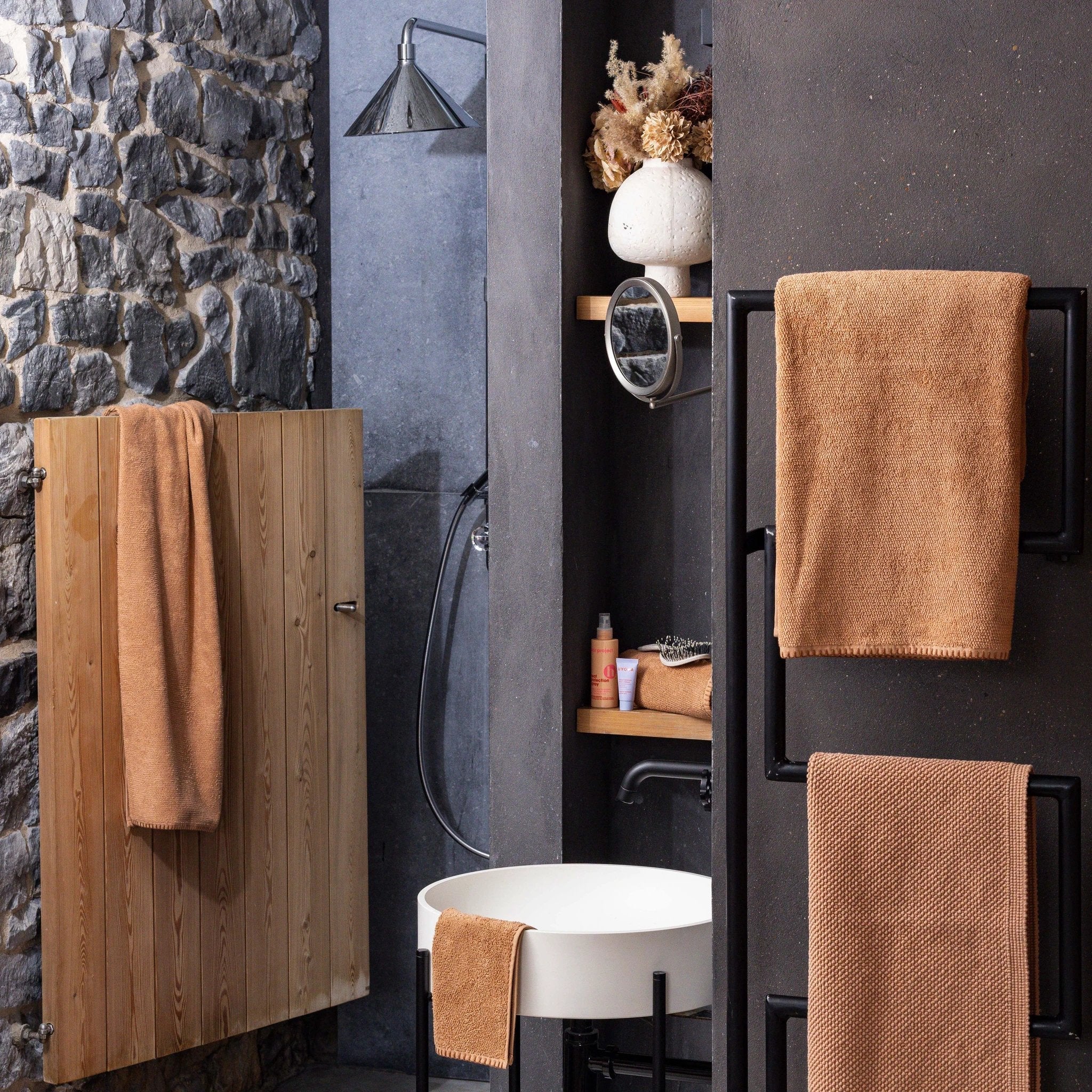 Collection de linge de bain haut de gamme en diverses couleurs suspendue sur un mur blanc minimaliste