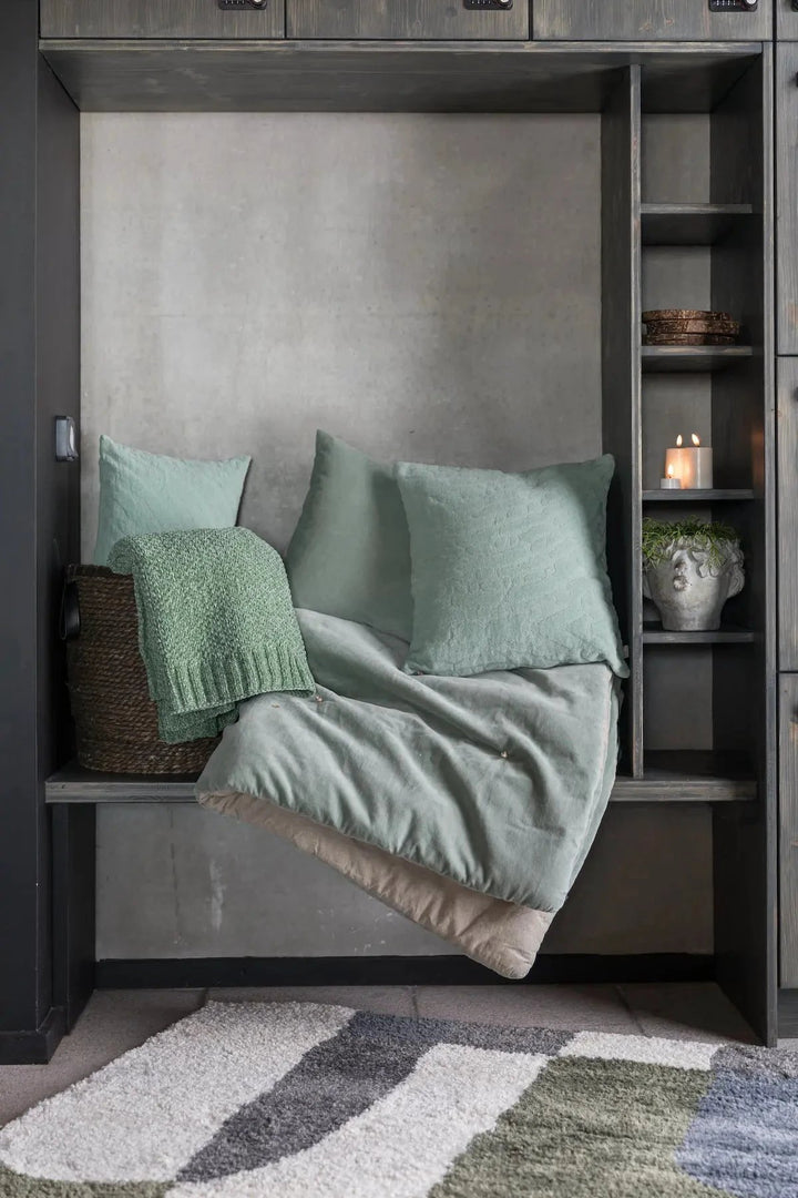 Chemin de lit Vivaraise vert avec coussins et couverture assortie dans un décor moderne