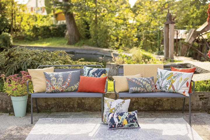 Plaid beige Vivaraise sur banc extérieur avec coussins colorés dans un jardin ensoleillé
